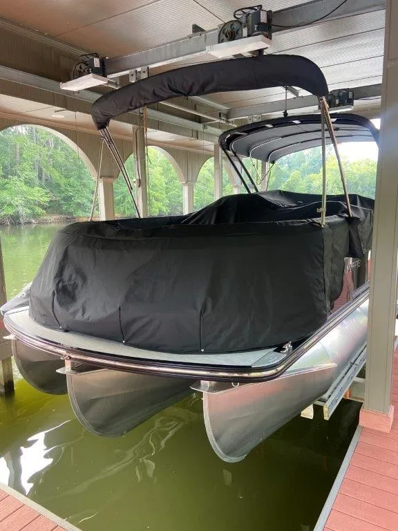 Slide: The Image of 2023 Harris FloteBote 250 Grand Mariner pontoon boat covered in dock. - 2