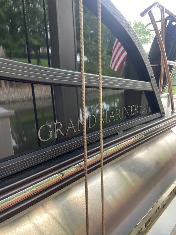 Slide: The Image of 2023 Harris FloteBote 250 Grand Mariner boat with American flag reflection. - 20