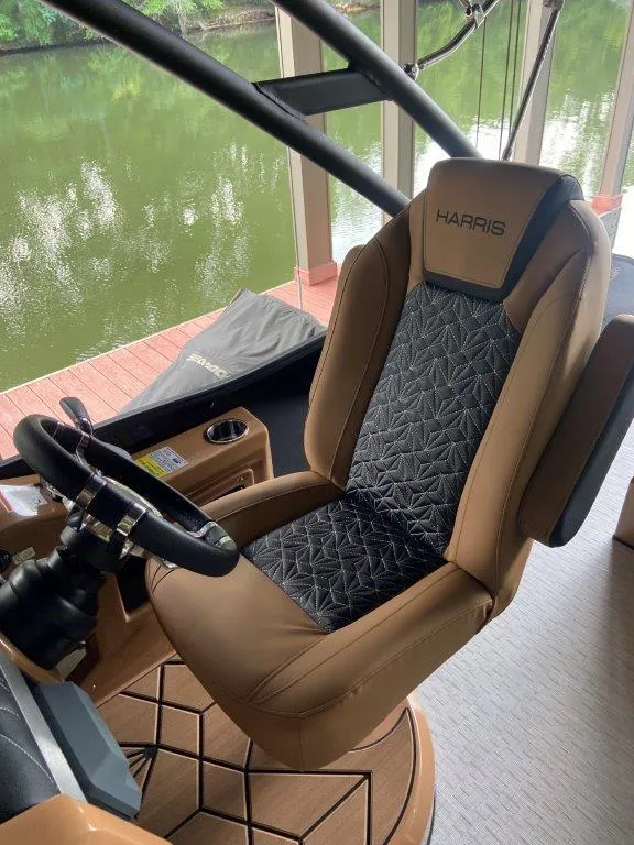Slide: The Image of Captain's chair on 2023 Harris FloteBote 250 Grand Mariner, overlooking serene water. - 5