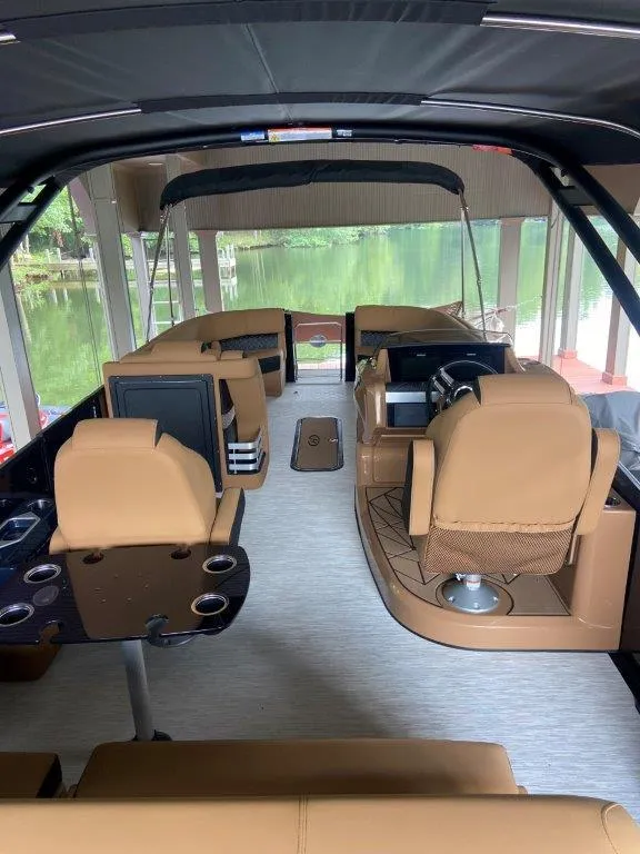 Slide: The Image of 2023 Harris FloteBote Grand Mariner 250 interior with tan seating and modern amenities. - 13