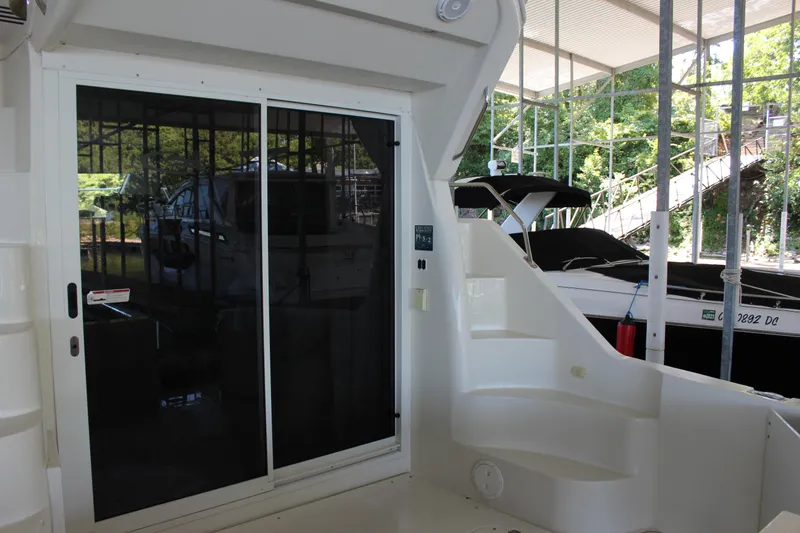 Slide: The Image of 2009 Carver 36SS yacht with sliding glass door and docked boats in background. - 14