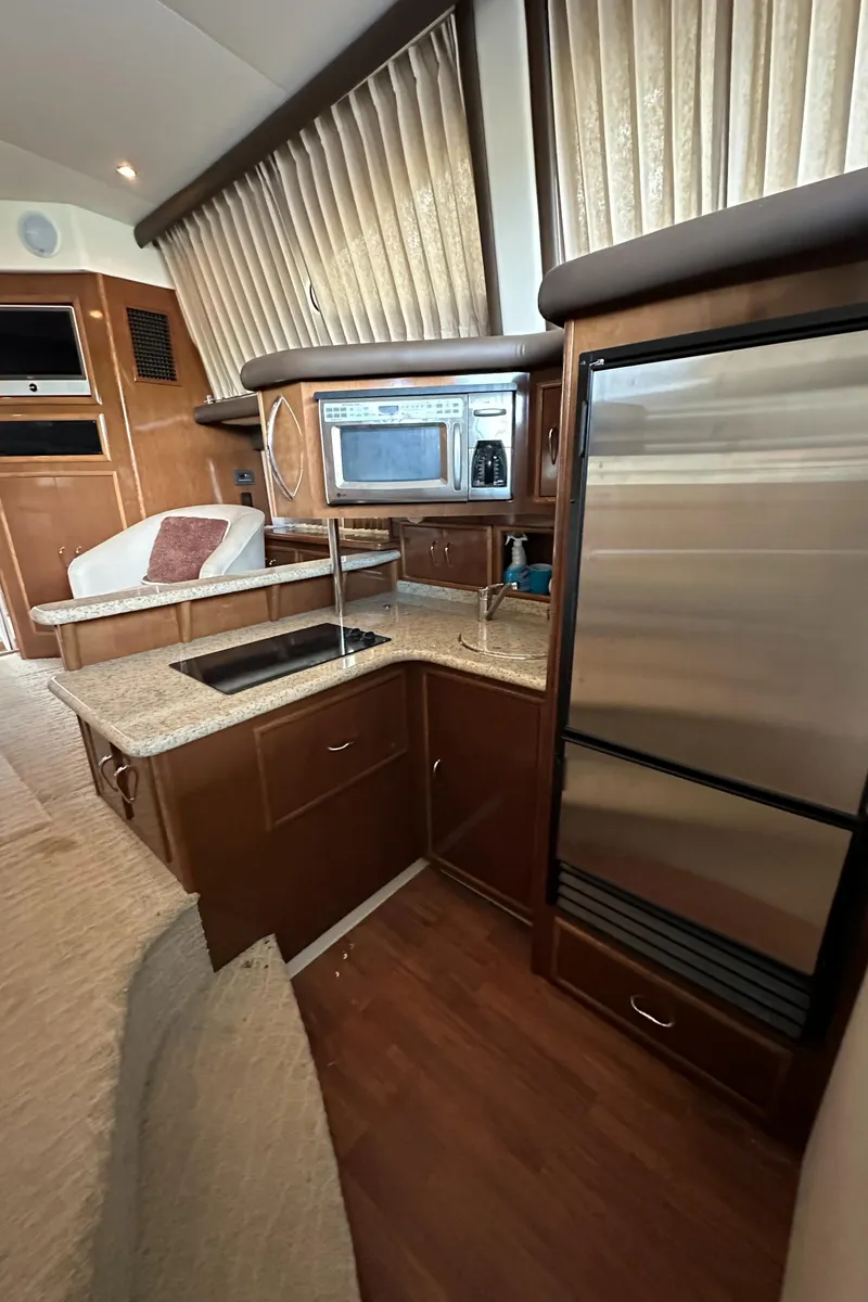 Slide: The Image of 2009 Carver 36SS yacht interior with modern kitchen and stainless steel appliances. - 36