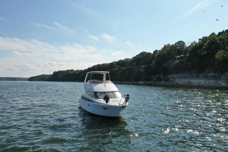Slide: The Image of 2009 Carver 36SS yacht cruising on a scenic lake with cliffs and trees. - 6