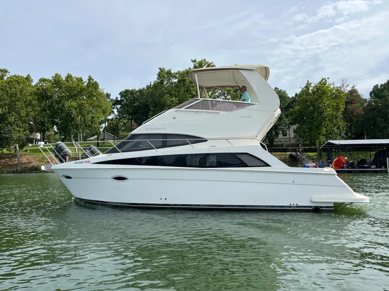 Slide: The Image of 2009 Carver 36SS yacht on a calm lake with trees in the background. - 8