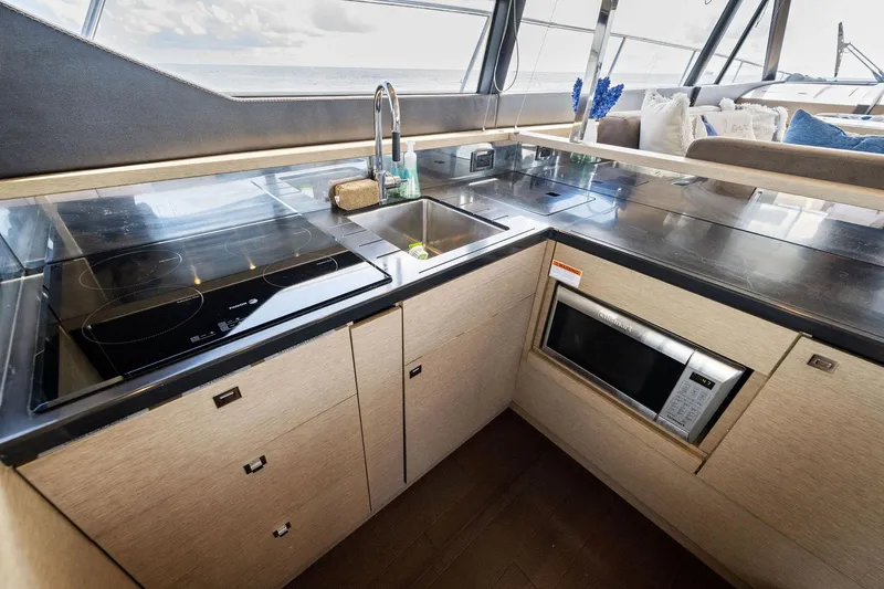 Slide: The Image of Modern kitchen area in a 2016 Prestige 620 yacht with sink, stove, and microwave. - 24