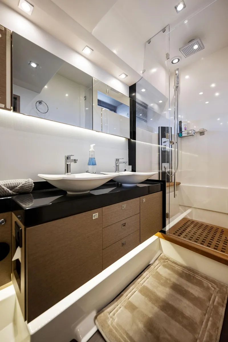 Slide: The Image of Modern bathroom in 2016 Prestige 620 yacht with dual sinks and glass shower. - 32