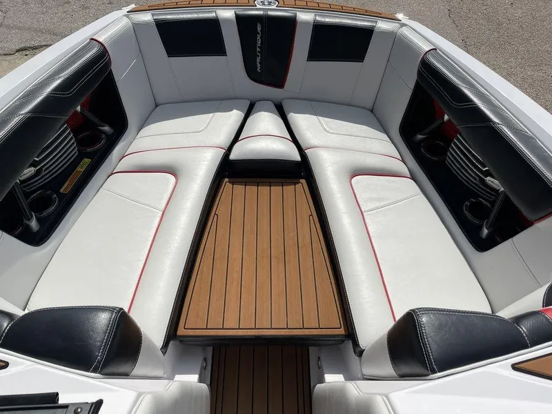 Slide: The Image of 2015 Nautique G23 boat interior with white and black seating, wooden flooring. - 4