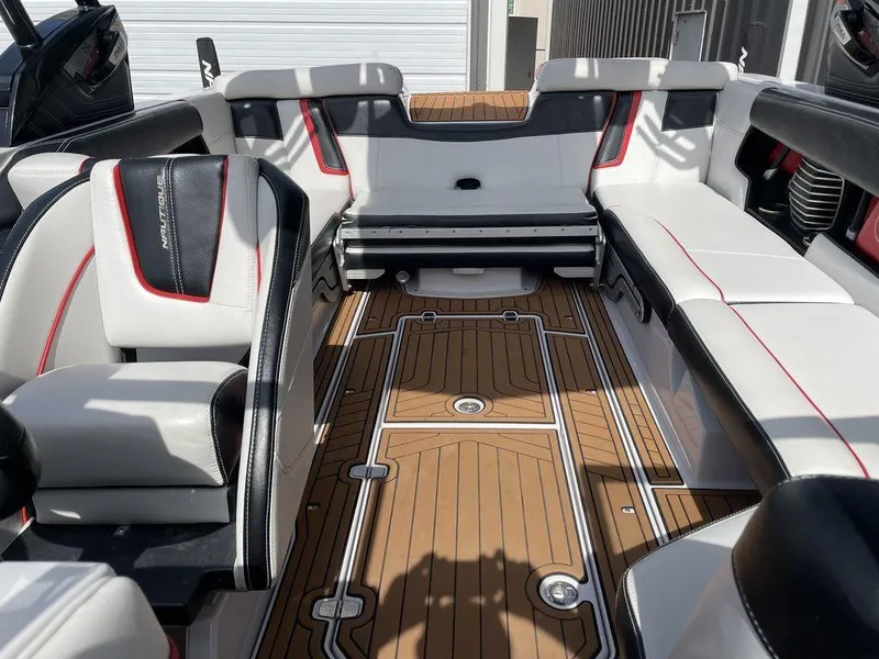 Slide: The Image of 2015 Nautique G23 boat interior with white and black seating, teak flooring. - 5