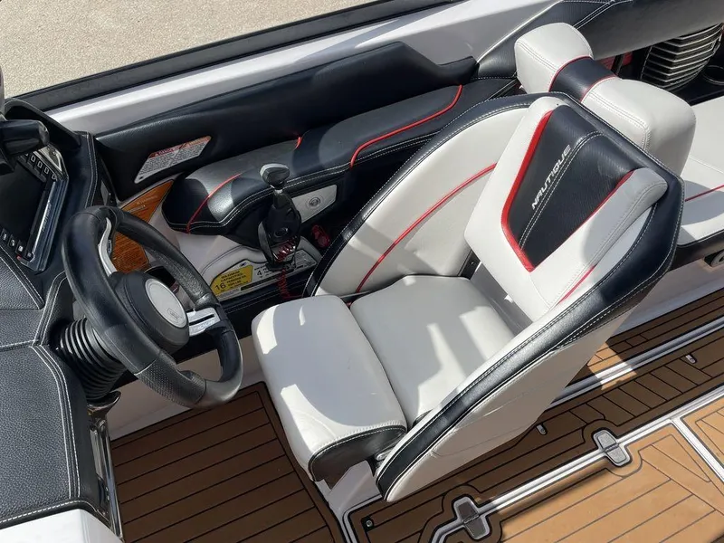 Slide: The Image of 2015 Nautique G23 boat cockpit with steering wheel and captain's seat. - 6