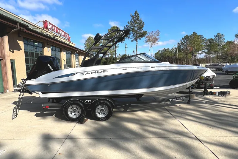 Slide: The Image of 2024 Tahoe 210 S boat on a trailer outside a boat service center. - 1