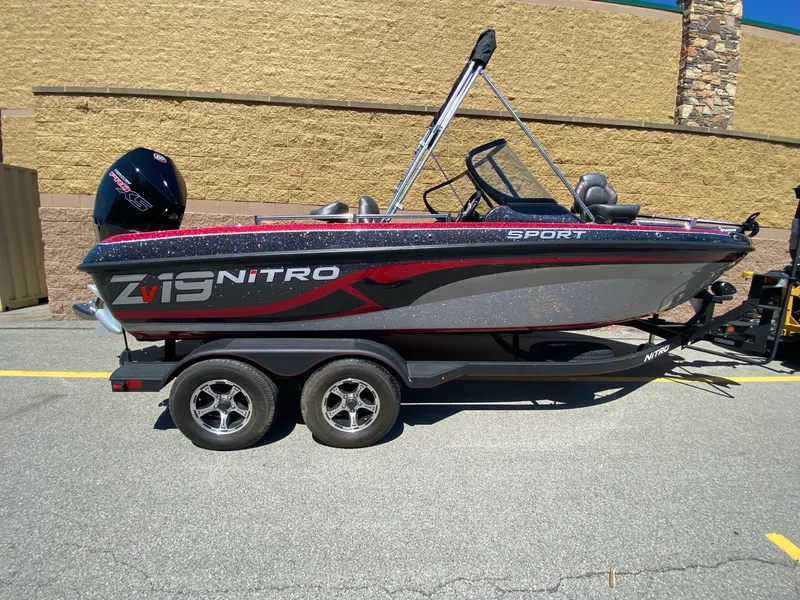 The Image of 2024 Nitro ZV19 Sport Pro boat on trailer, side view in outdoor setting. - 0