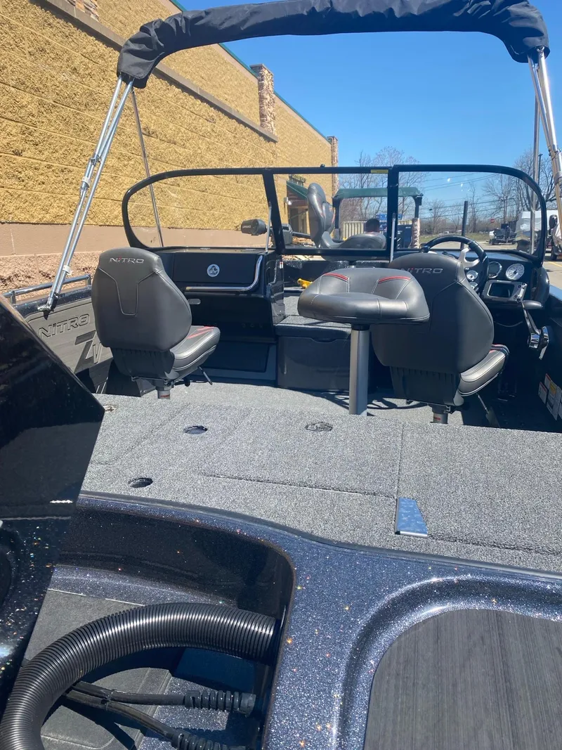 Slide: The Image of 2024 Nitro ZV19 Sport Pro boat interior with seating and dashboard, under clear blue sky. - 4