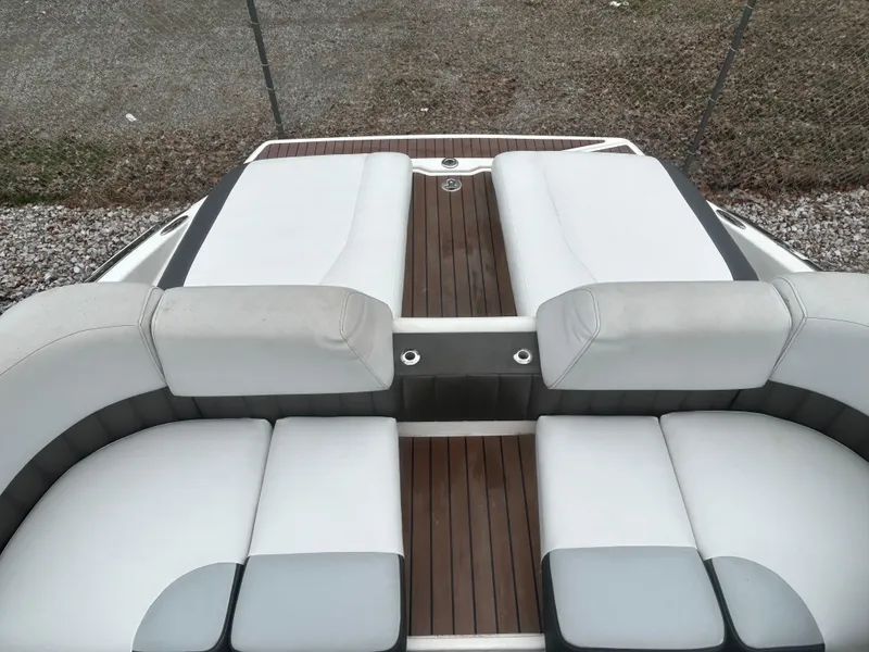 Slide: The Image of 2011 Regal 2500 Bowrider boat with white and gray seating and wooden deck. - 10