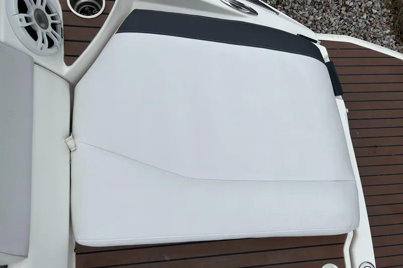 Slide: The Image of 2011 Regal 2500 Bowrider white cushioned seat on wooden deck. - 11