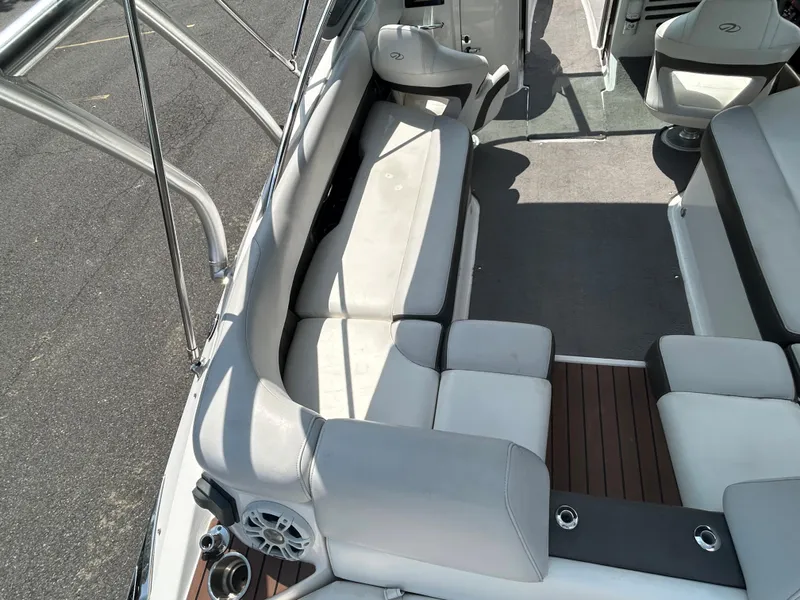Slide: The Image of 2011 Regal 2500 Bowrider boat interior with white seating and wood flooring. - 16