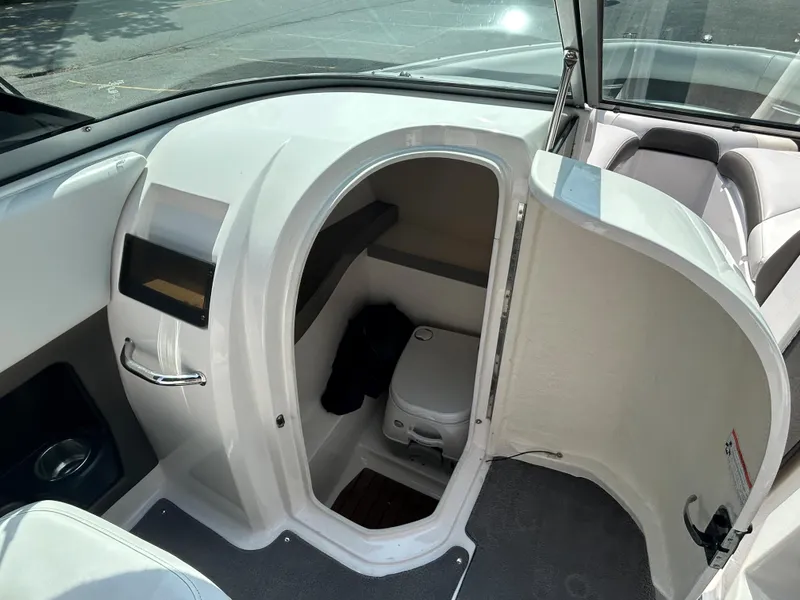 Slide: The Image of 2011 Regal 2500 Bowrider boat interior with a small cabin and toilet. - 24