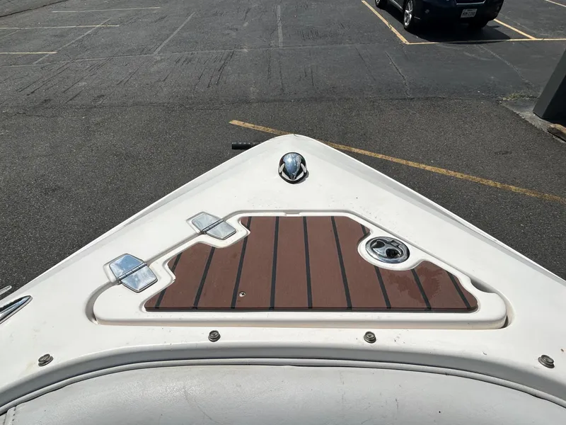 Slide: The Image of 2011 Regal 2500 Bowrider boat bow with teak deck in a parking lot. - 28