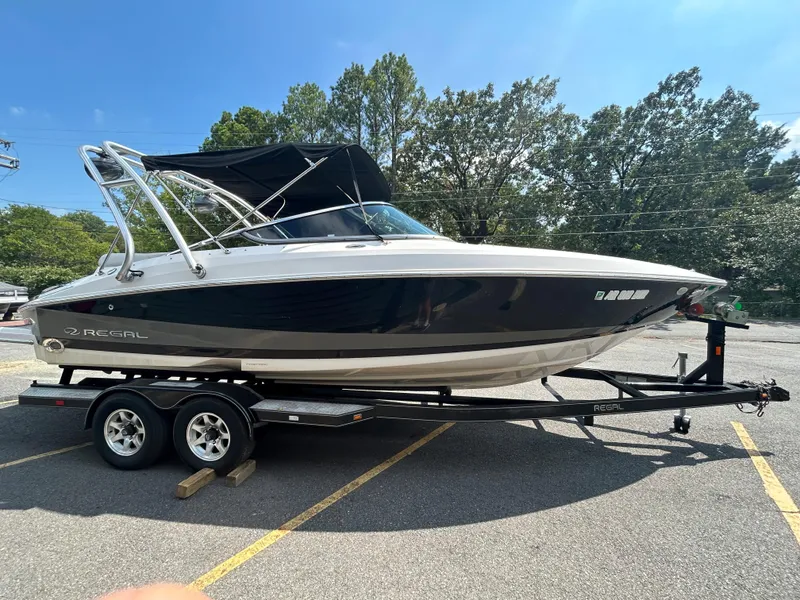 Slide: The Image of 2011 Regal 2500 Bowrider boat on a trailer in a parking lot. - 3