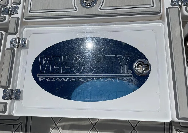Slide: The Image of 2023 Velocity 260 Bay Powerboat logo on a compartment lid. - 11