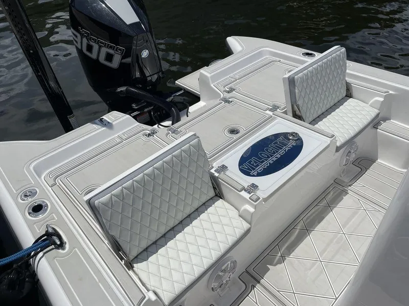 Slide: The Image of 2023 Velocity 260 Bay boat with cushioned seating and powerful outboard motor. - 12