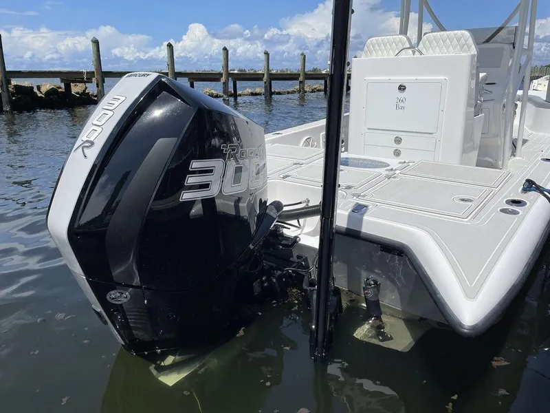 Slide: The Image of 2023 Velocity 260 Bay boat with a powerful 300 HP outboard engine docked in calm waters. - 13