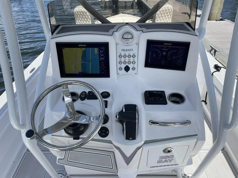 Slide: The Image of 2023 Velocity 260 Bay boat dashboard with navigation screens and steering wheel. - 5