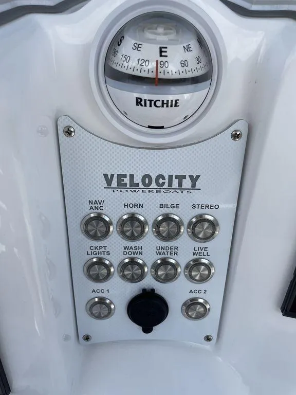 Slide: The Image of 2023 Velocity 260 Bay boat control panel with compass and switches. - 7