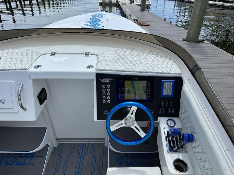 Slide: The Image of 2024 Velocity 290sc boat dashboard with navigation system and blue steering wheel. - 10