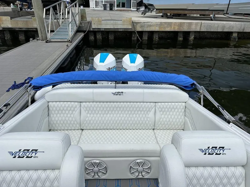 Slide: The Image of 2024 Velocity 290sc boat interior with white leather seats and twin outboard engines. - 15