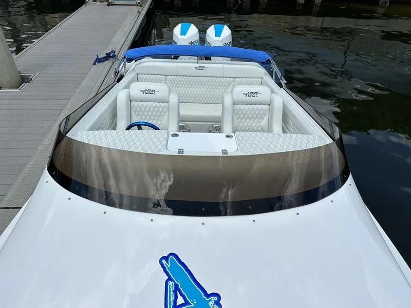 Slide: The Image of 2024 Velocity 290sc speedboat docked, featuring white leather seats and twin outboard engines. - 16