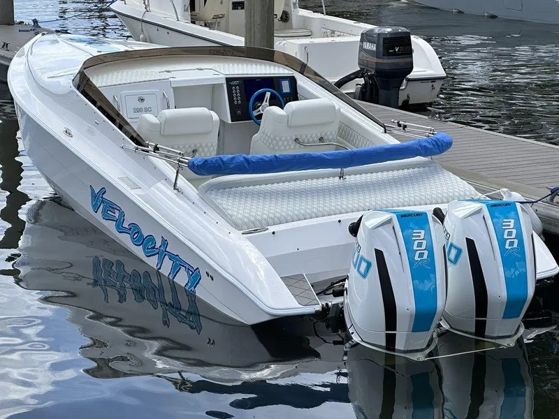 Slide: The Image of 2024 Velocity 290sc speedboat docked with twin 300 horsepower engines. - 27