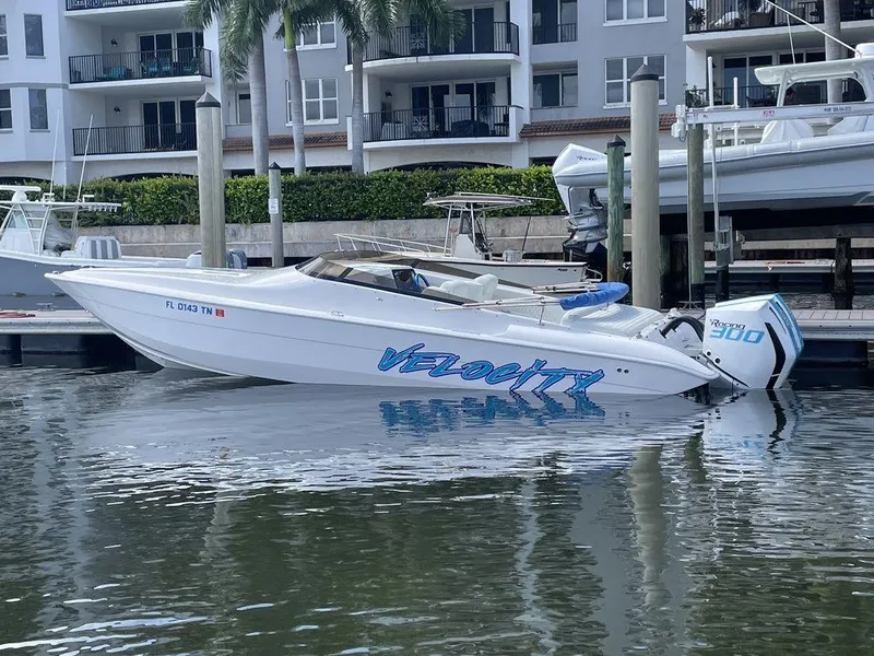 Slide: The Image of 2024 Velocity 290sc speedboat docked at marina with waterfront apartments in background. - 35