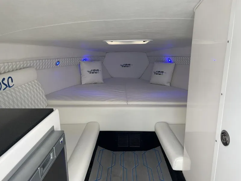 Slide: The Image of 2024 Velocity 290sc boat interior cabin with white seating and blue LED lights. - 38
