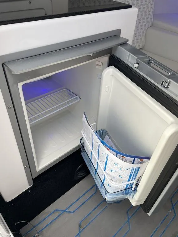 Slide: The Image of 2024 Velocity 290sc boat interior with open mini fridge. - 39