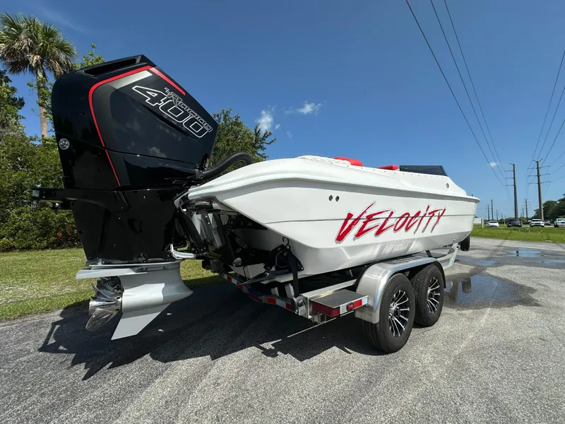 The Image of 2025 Velocity 290 SC boat on trailer with powerful outboard motor, parked outdoors. - 0