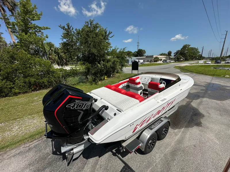 Slide: The Image of 2025 Velocity 290 SC speedboat with red seating and powerful outboard motor on a trailer. - 14
