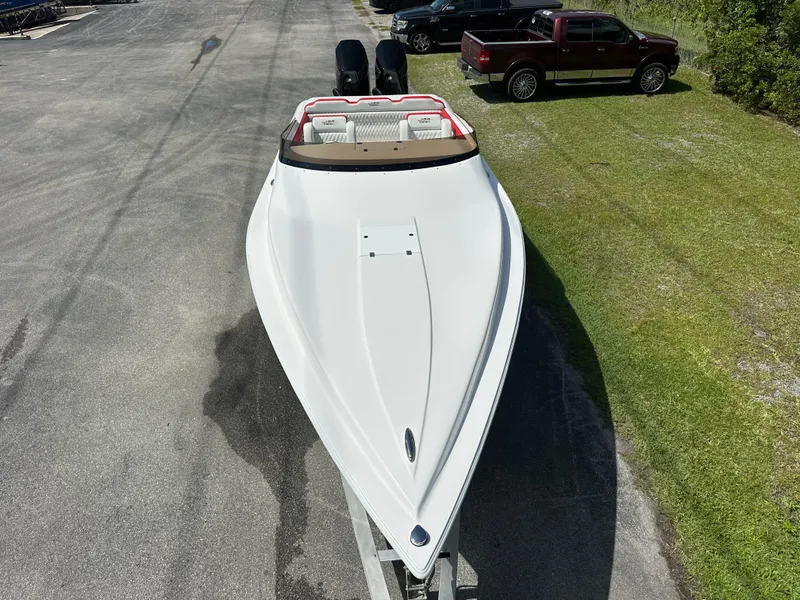 Slide: The Image of 2025 Velocity 290 SC speedboat on trailer, viewed from above, parked near grass and pavement. - 15