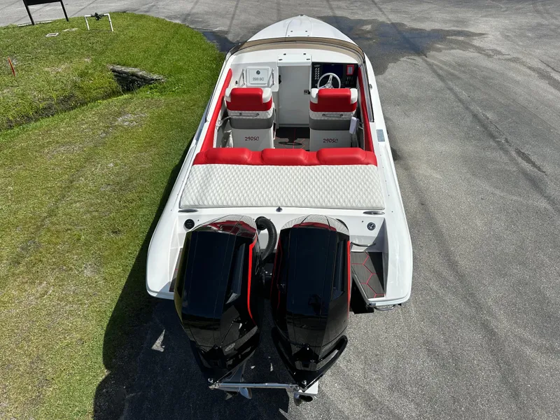 Slide: The Image of 2025 Velocity 290 SC speedboat with dual engines, red and white seating, parked on pavement. - 16