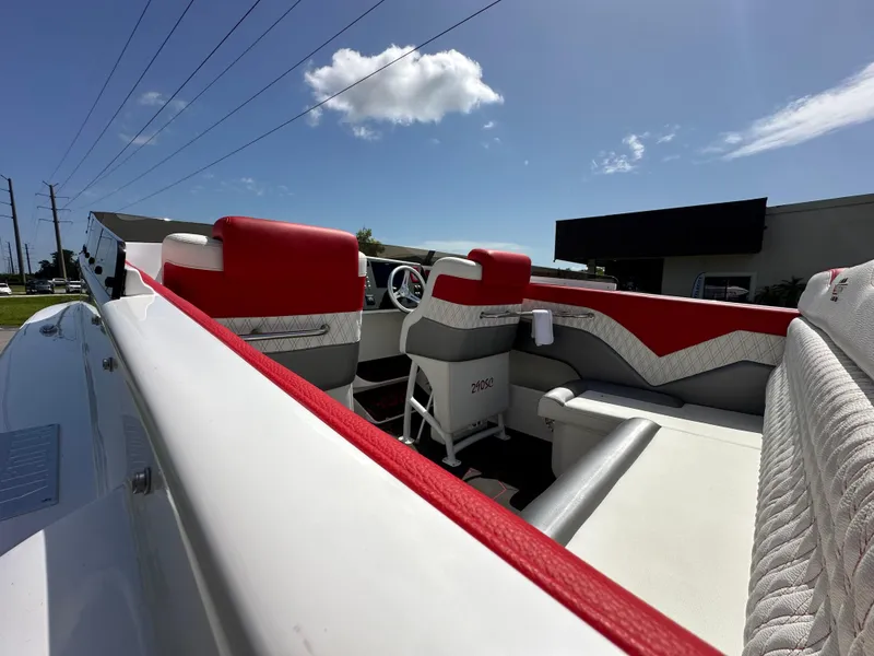 Slide: The Image of 2025 Velocity 290 SC boat interior with red and white seating under a clear blue sky. - 17