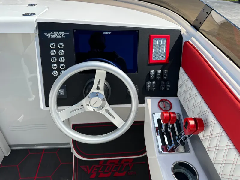 Slide: The Image of 2025 Velocity 290 SC boat dashboard with steering wheel, controls, and red accents. - 18