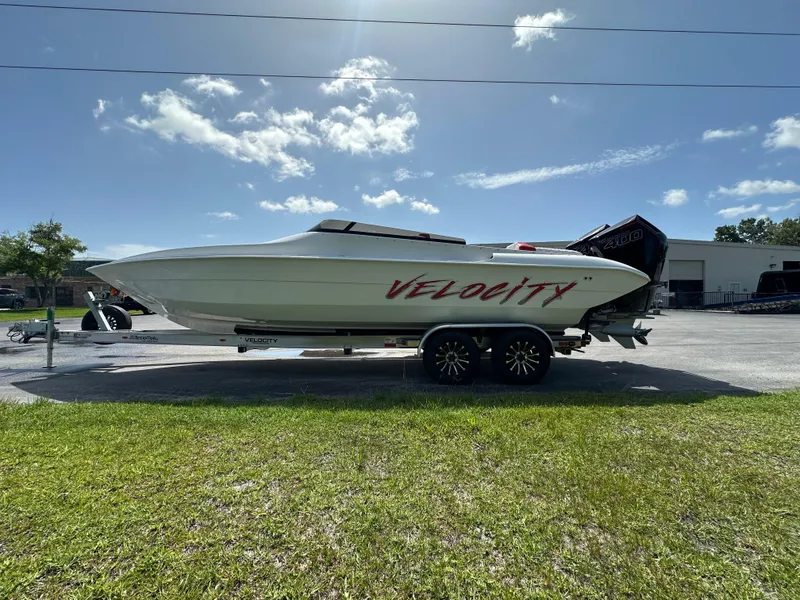 Slide: The Image of 2025 Velocity 290 SC speedboat on trailer under clear sky. - 2