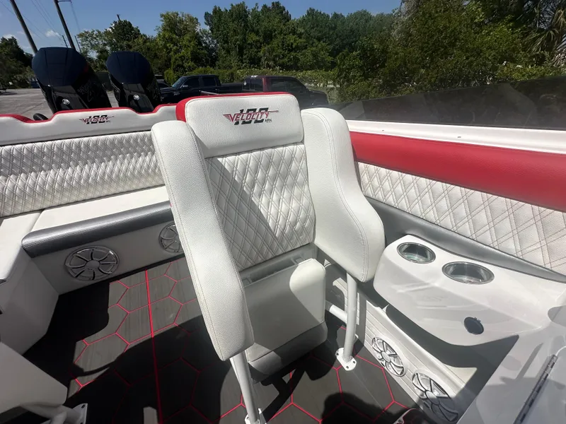 Slide: The Image of 2025 Velocity 290 SC boat interior with white and red seating, cup holders, and speakers. - 23
