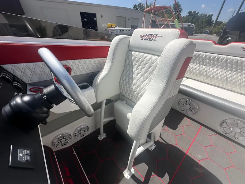 Slide: The Image of 2025 Velocity 290 SC boat interior with white quilted seats and modern steering wheel. - 24