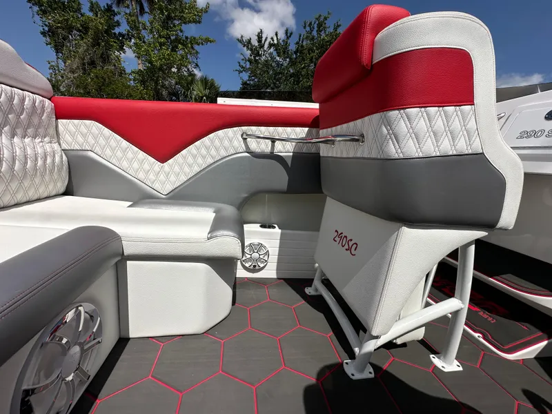 Slide: The Image of 2025 Velocity 290 SC boat interior with red and gray seating, quilted design, and hexagonal flooring. - 29