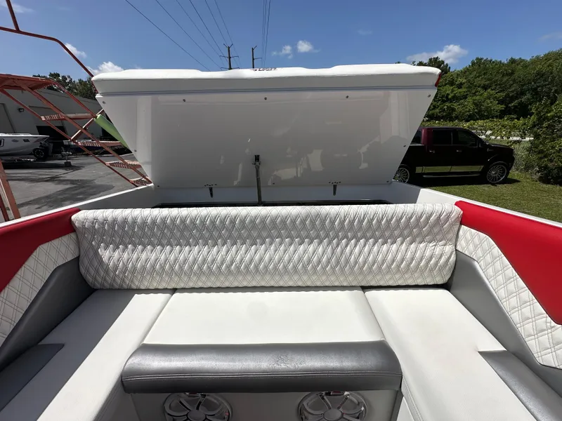 Slide: The Image of 2025 Velocity 290 SC boat interior with white and red seating, open storage compartment. - 30