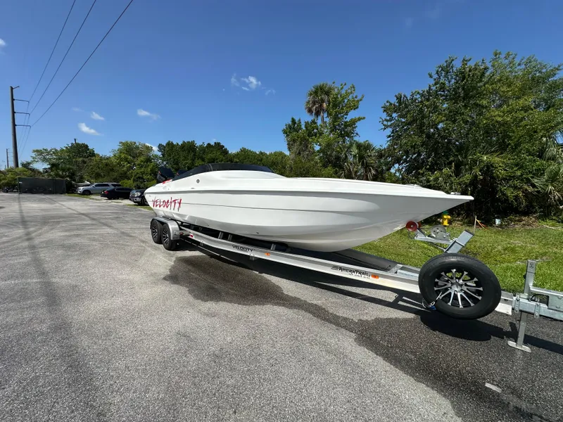 Slide: The Image of 2025 Velocity 290 SC boat on trailer, parked outdoors under clear blue sky. - 4