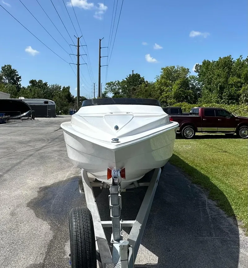 Slide: The Image of 2025 Velocity 290 SC boat on trailer, parked outdoors under clear blue sky. - 5