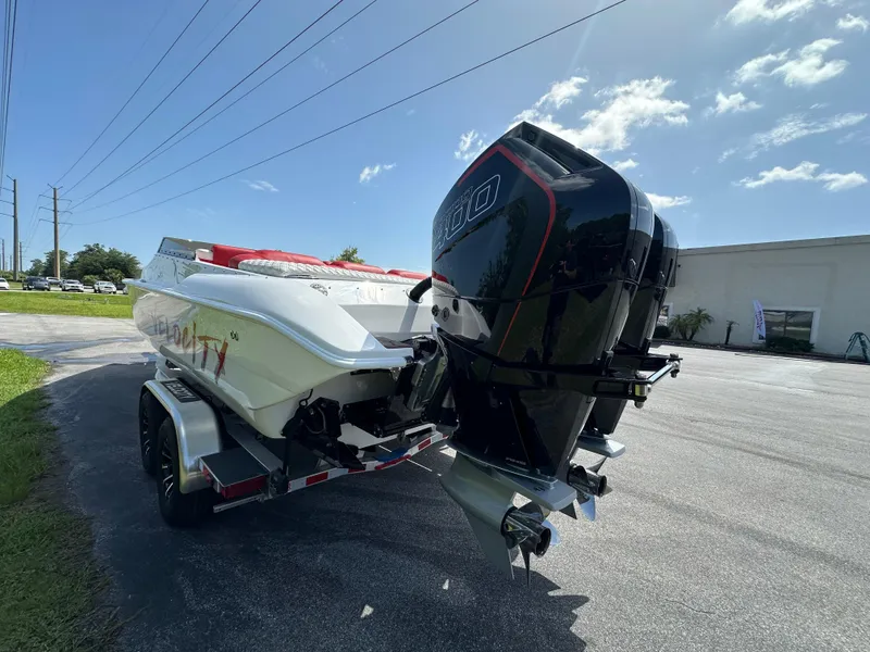 Slide: The Image of 2025 Velocity 290 SC boat on trailer with powerful outboard motor under clear sky. - 7