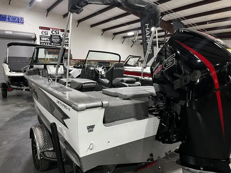 Slide: The Image of 2024 Lund 1875 Pro V Sport boat with powerful outboard motor in showroom. - 4