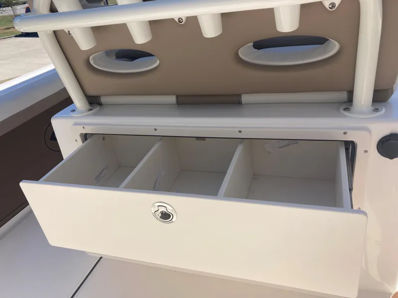 Slide: The Image of 2024 Sea Born LX24 boat storage compartment with open drawer and rod holders. - 5
